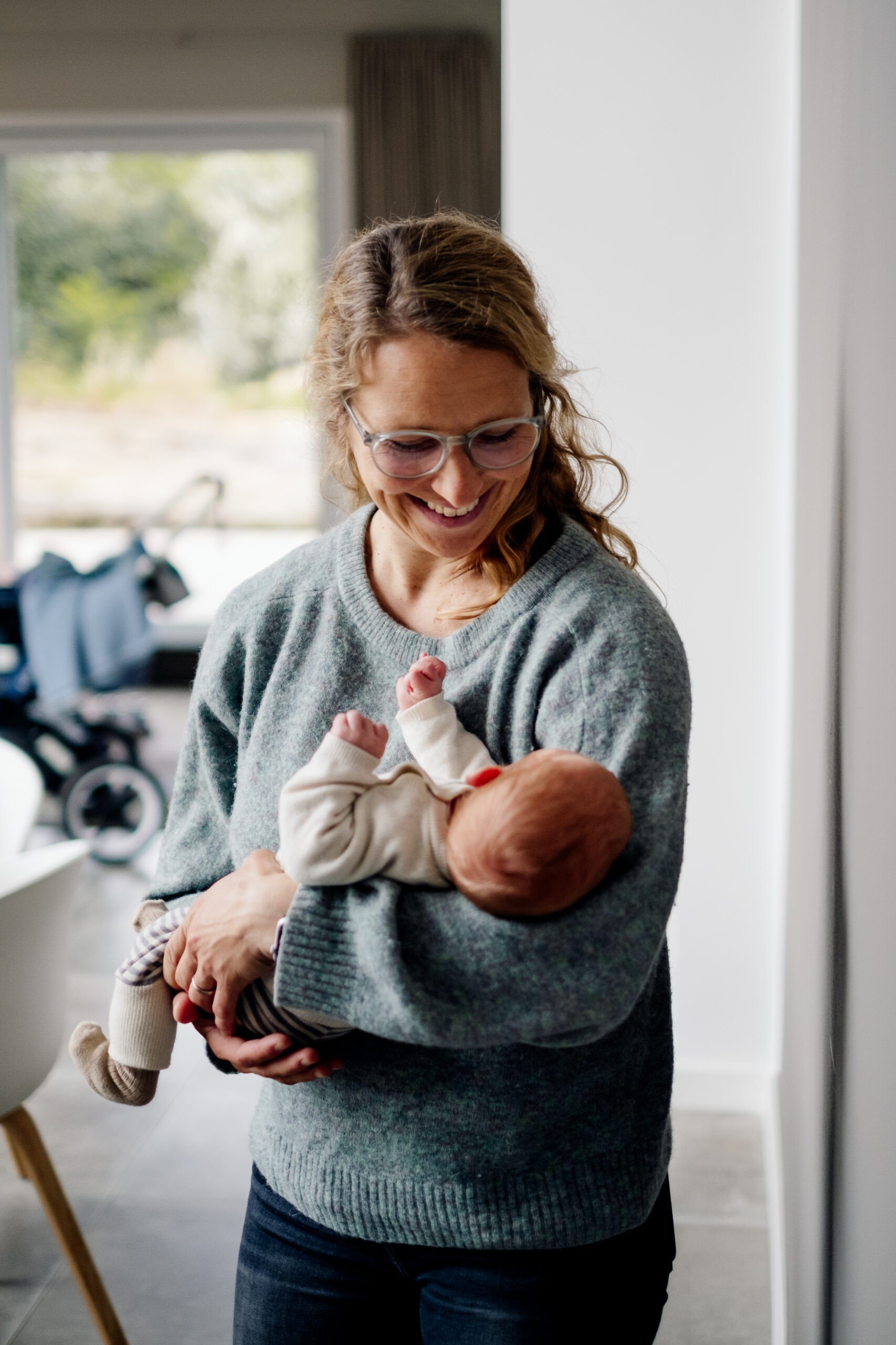 Mutter wiegt stehend Baby im Arm