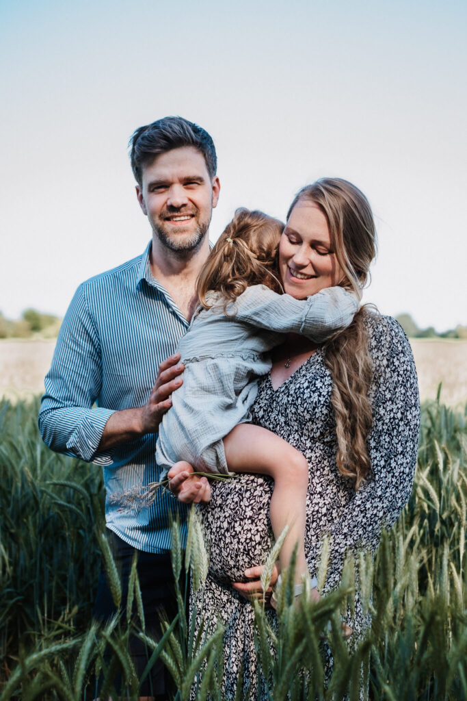 Foto einer Familie mit einer schwangeren Frau im Kornfeld