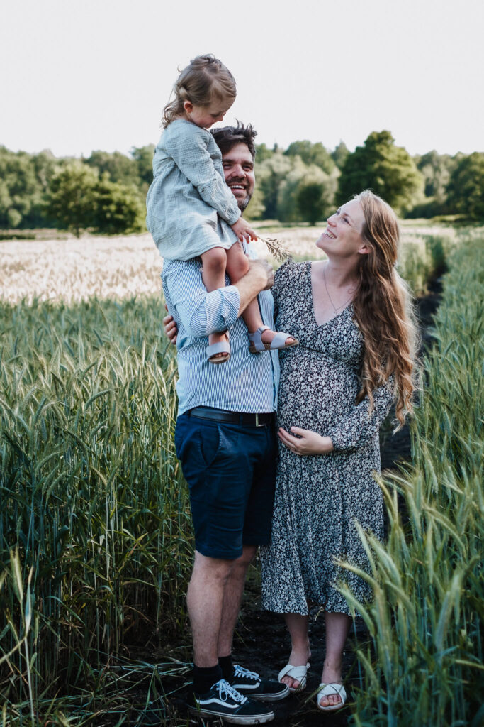 Foto einer Familie mit Tochter und schwangerer Frau im Kornfeld