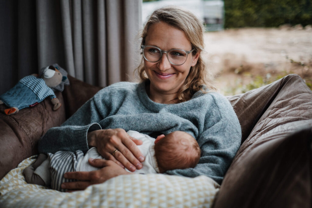 Mutter stillt ihr Baby und lächelt glücklich