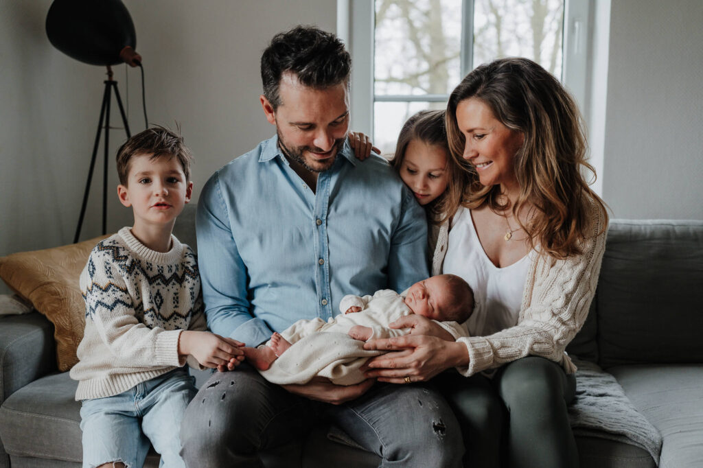 Neugeborenes in den Armen der Eltern – Familie in Flensburg bei einem Fotoshooting
