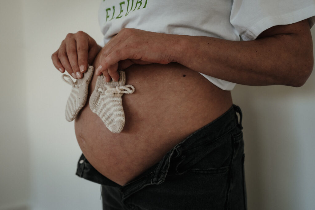 Babybauch mit kleinen Söckchen davor