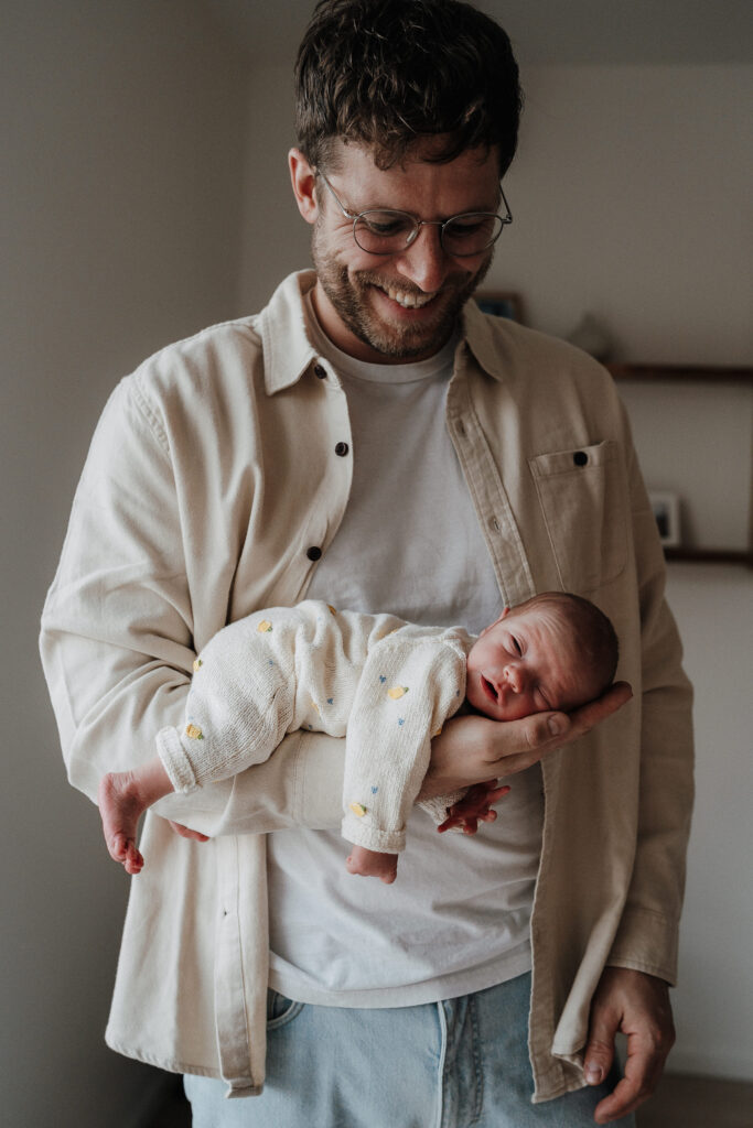 Vater mit Baby auf dem Arm bei einer Wochenbett Reportage in Flensburg