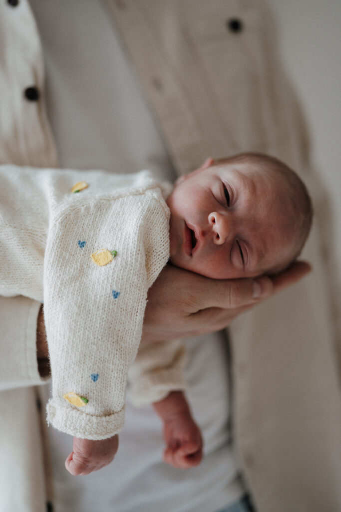 Portrait eines Neugeborenen in Papas Hand