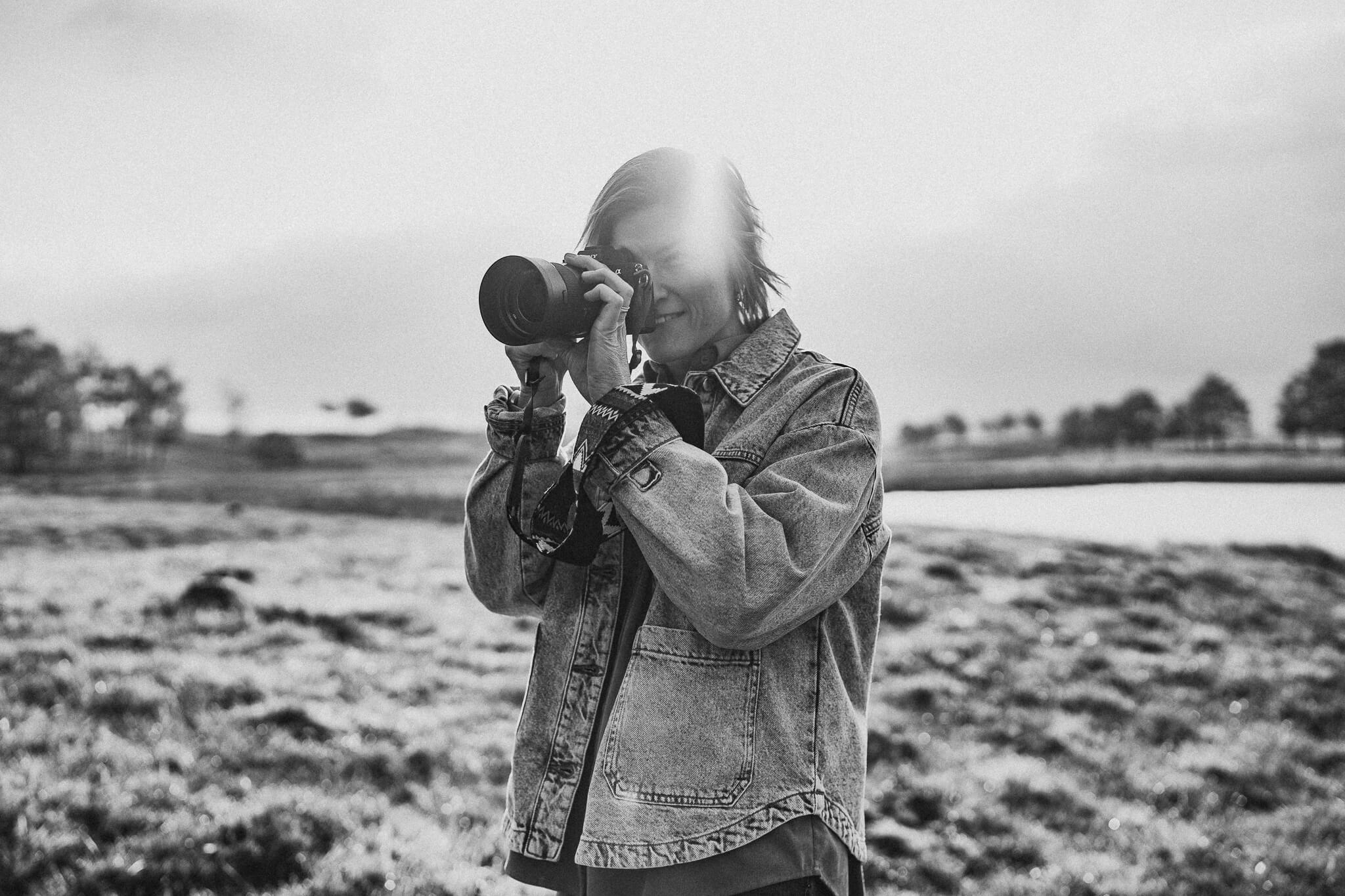 Schwarz weiß Bild einer Fotografin hinter der Kamera